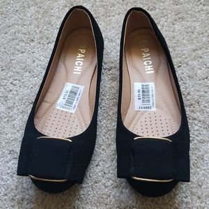 Black flats with a rose gold metal bow